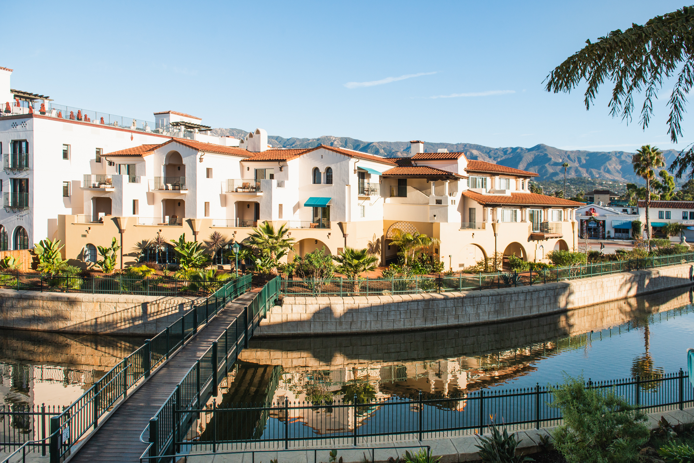 A white building with red roofs and a water view