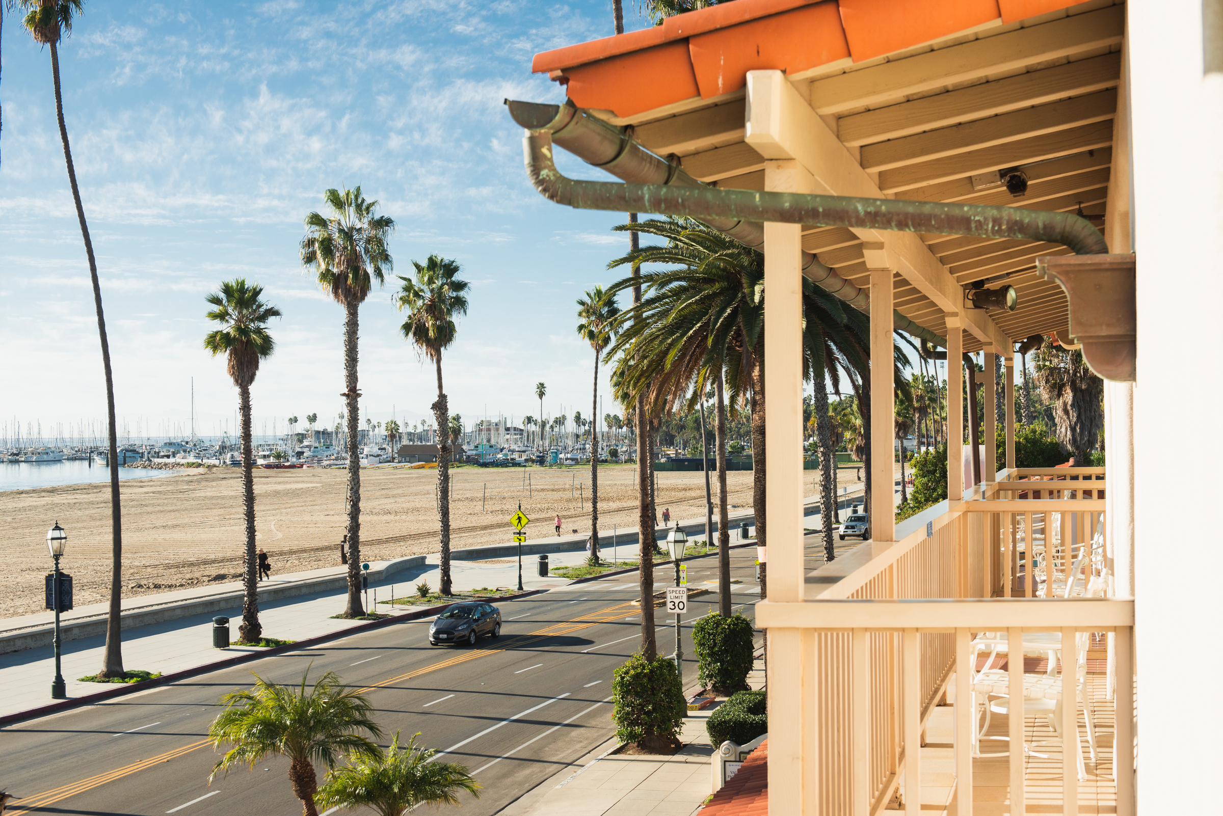 A balcony with a view of a beach and palm trees