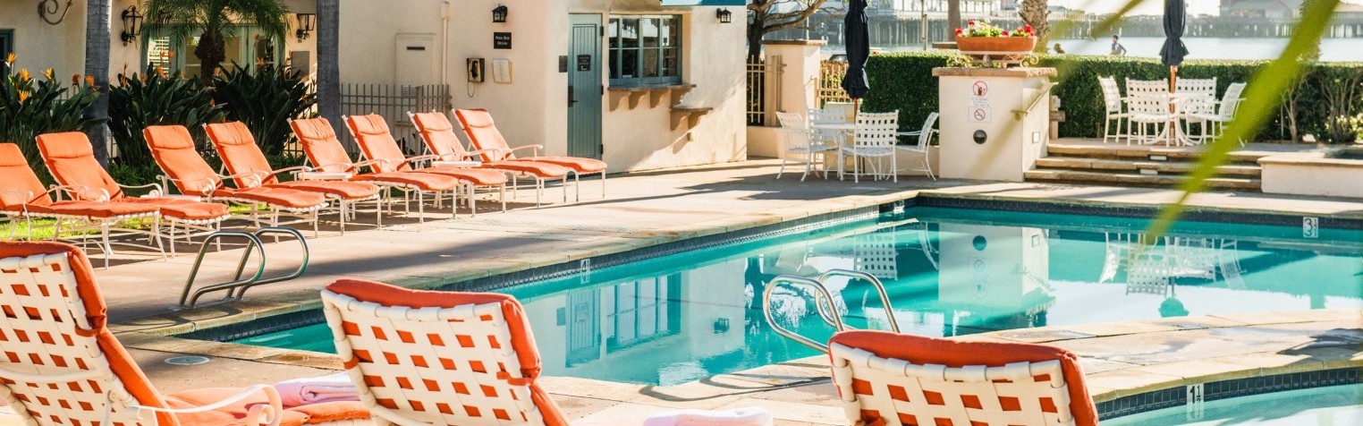 A poolside view featuring Harbor View's pool bar with lounging chairs